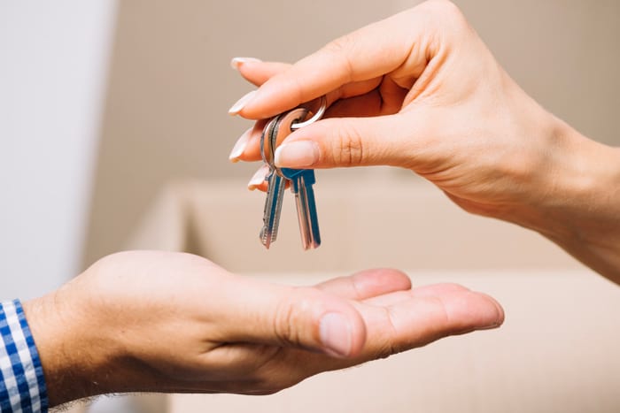 woman handing keys to a man